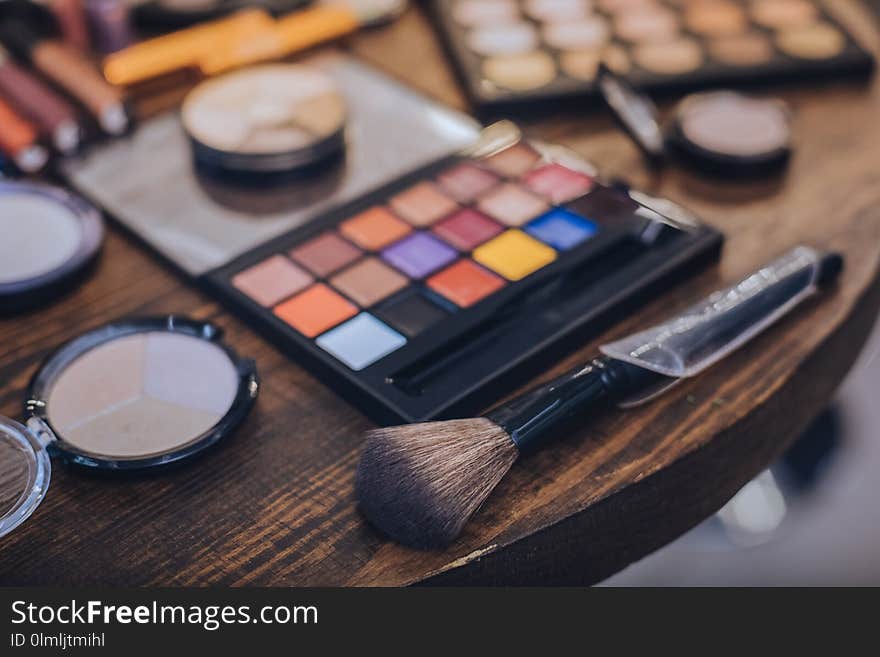 Little cosmetics brush lying on the table near eye shades palette