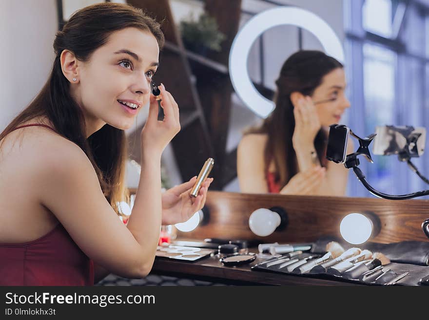 New mascara. Young beautiful student feeling extremely happy while using her new mascara. New mascara. Young beautiful student feeling extremely happy while using her new mascara