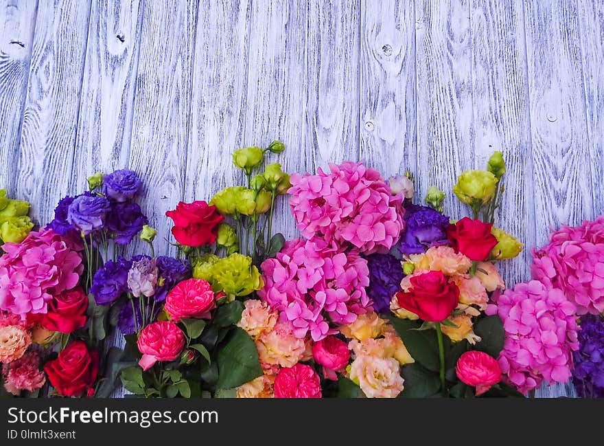 Flowers on vintage wooden background close-up. Beautiful floral frame - ready layout. Florist in the flower shop. Flowers on vintage wooden background close-up. Beautiful floral frame - ready layout. Florist in the flower shop