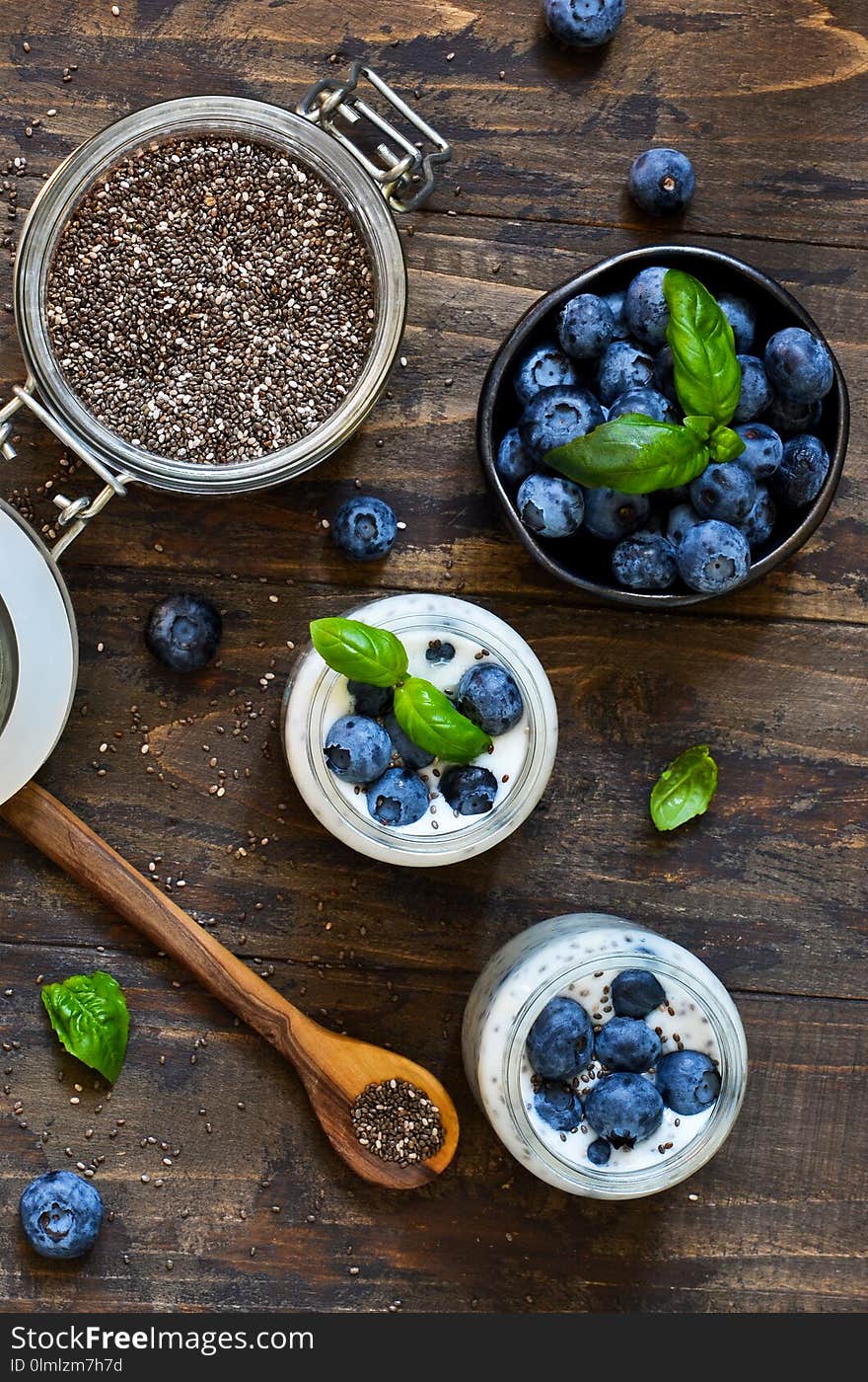 Homemade yogurt with sesena chia and blueberries that have a dark background.