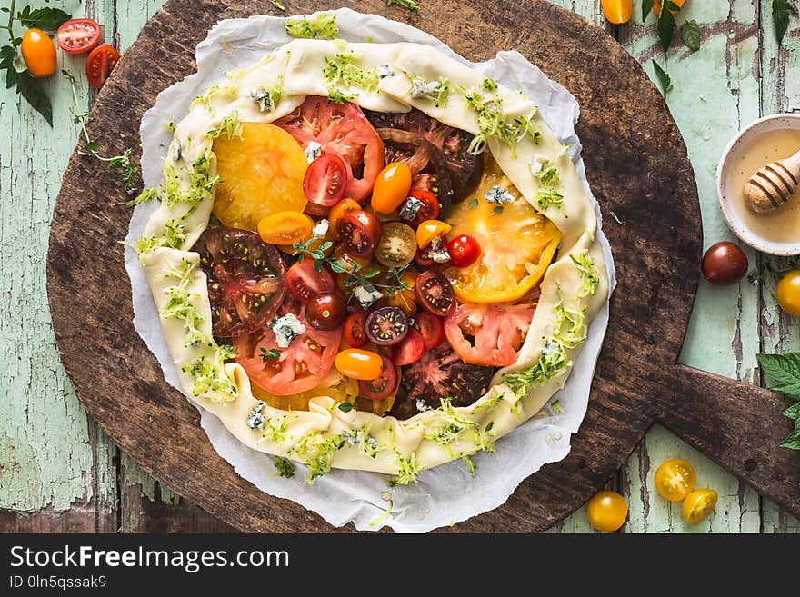 Heirloom Tomatoes Tart with Zucchini, Blue Cheese, Thyme and Honey on Wood Background