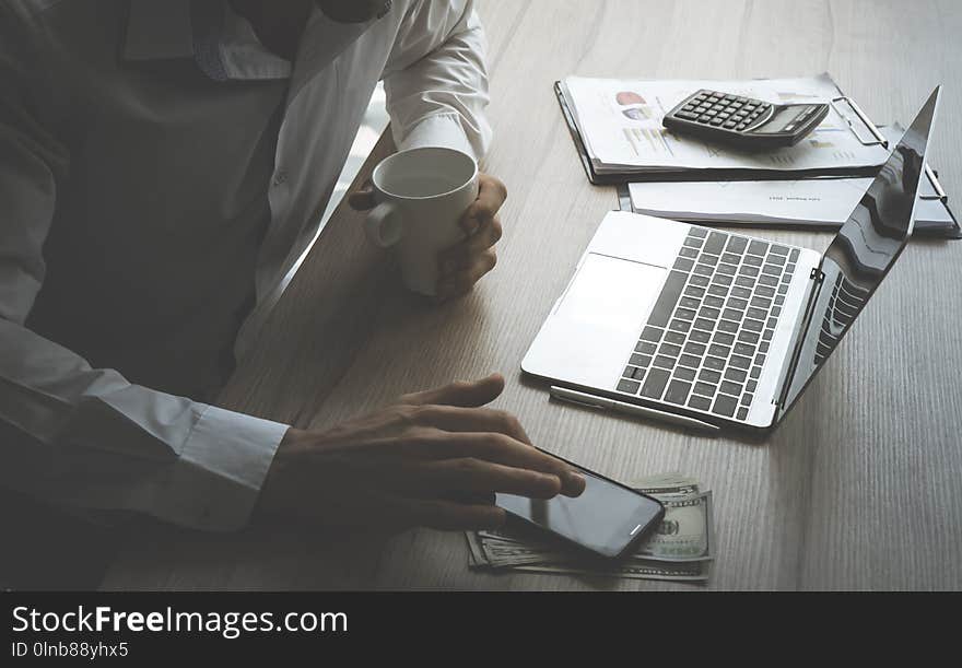 Business man using computer and mobile on table with financia