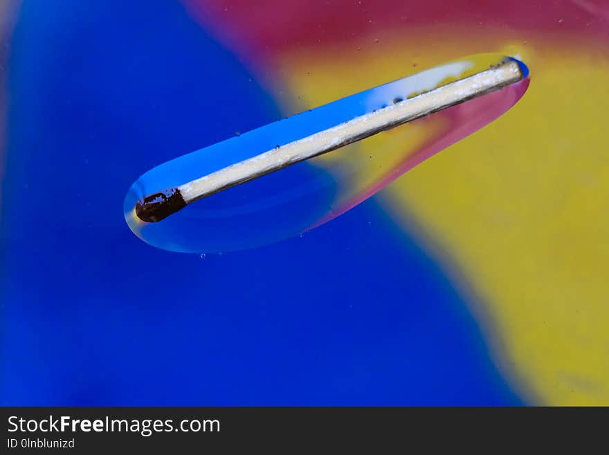 Match in a colorful background of water and oil drops