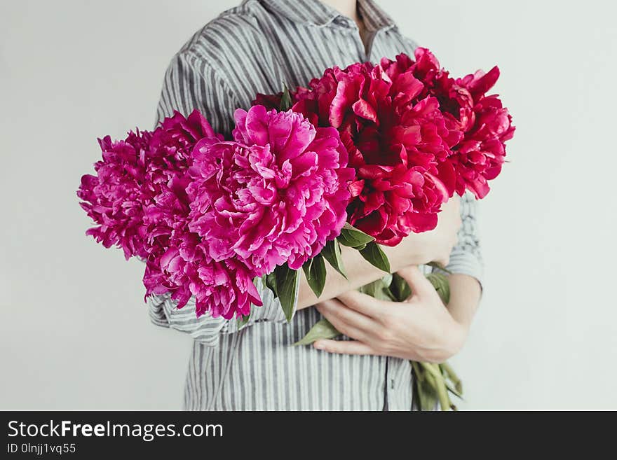 portrait of woman holding bouquet of violet and purple flowers