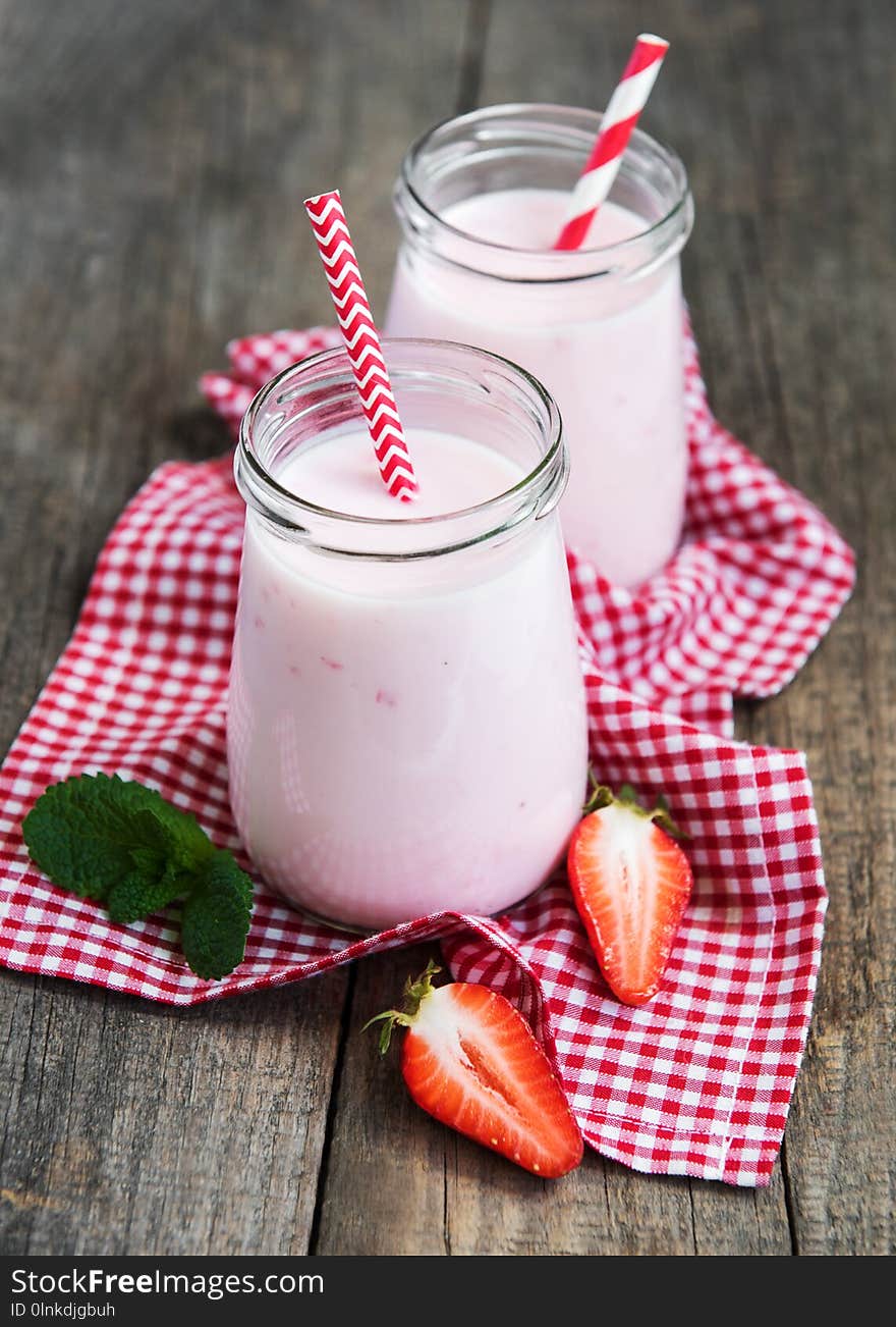 Jars with strawberry yogurt on a old wooden table