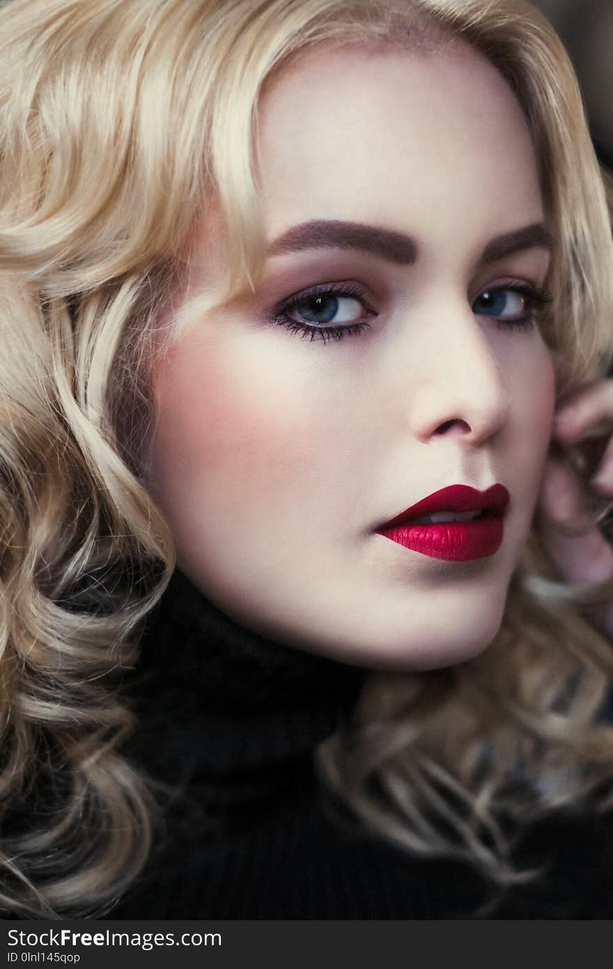 Portrait of elegant blond retro woman with beautiful velvet red lips, she touches her face. Portrait of elegant blond retro woman with beautiful velvet red lips, she touches her face.