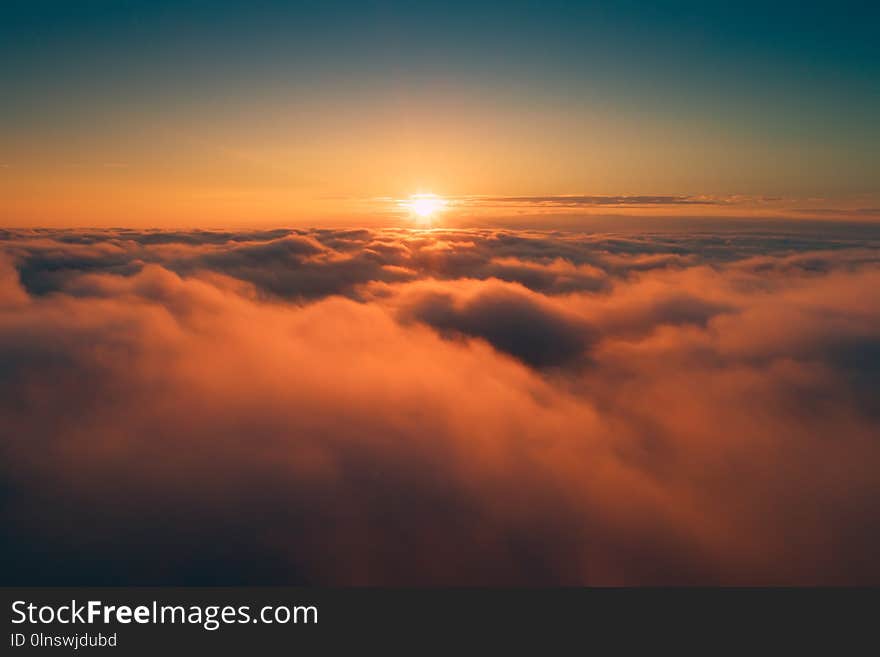 Orange clouds in the morning. Sun above clouds on clear sky background. Sunny cloudscape backdrop.