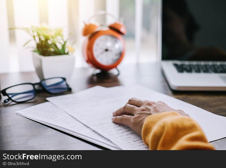 Happy casual young asian woman working in home or small office with using a laptop and document report on desk as a freelancer.