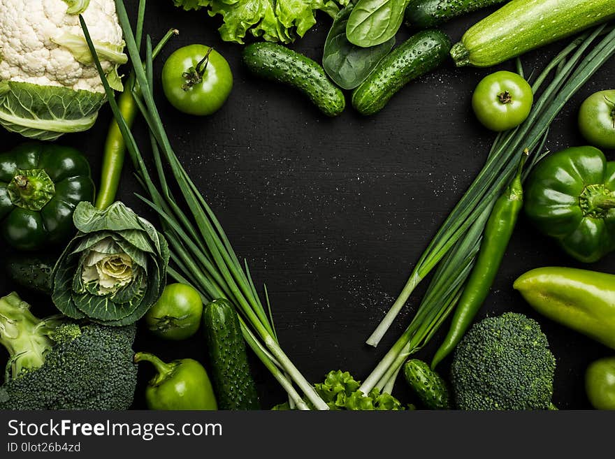 Heart shaped vegetables. Food photography of heart made from different vegetables on black background. Copy space, top view