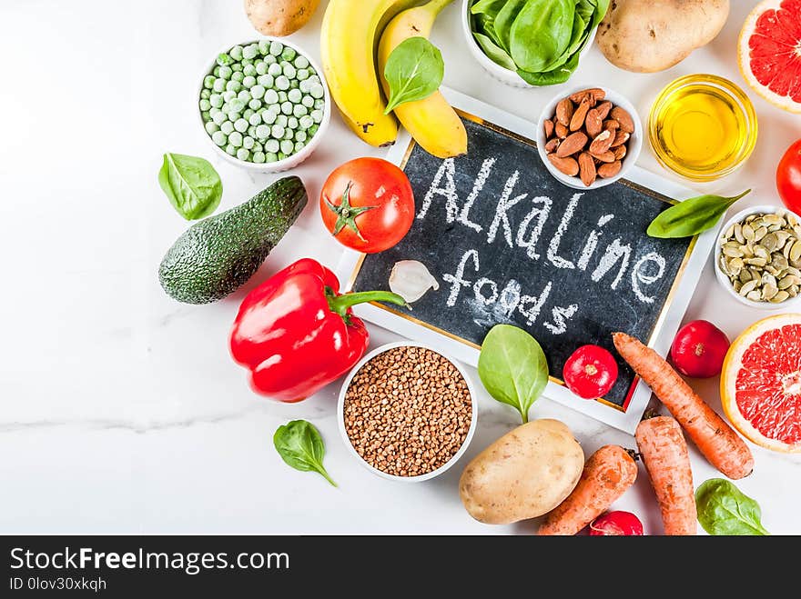 Healthy food background, trendy Alkaline diet products - fruits, vegetables, cereals, nuts. oils, white marble background top view copy space. Healthy food background, trendy Alkaline diet products - fruits, vegetables, cereals, nuts. oils, white marble background top view copy space