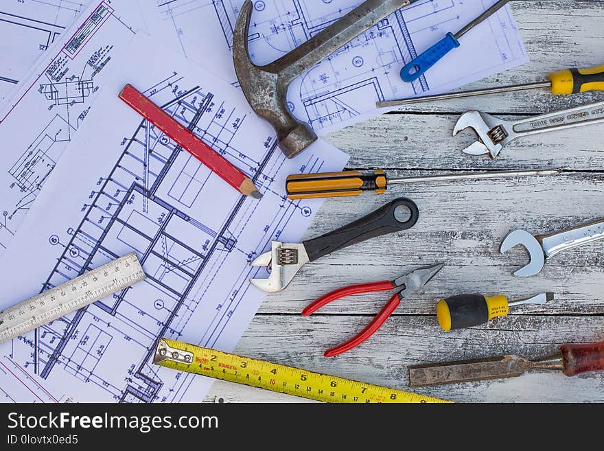 Set of construction tools and blueprints on the white,rustic wooden background