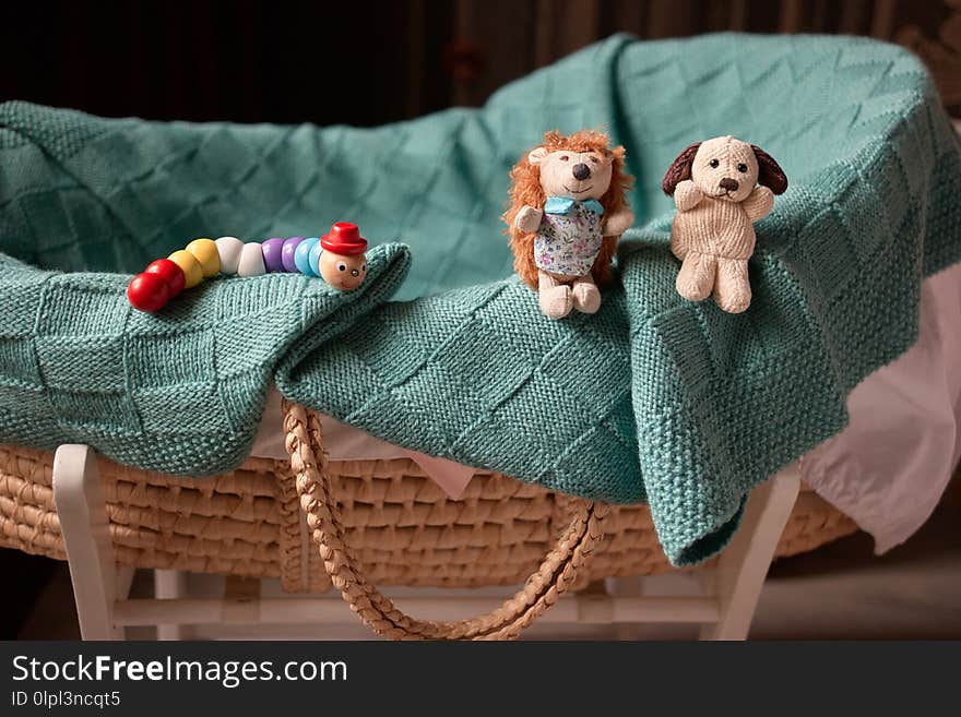 Baby basket and toys. Caterpillar, plush hedgehog and dog.