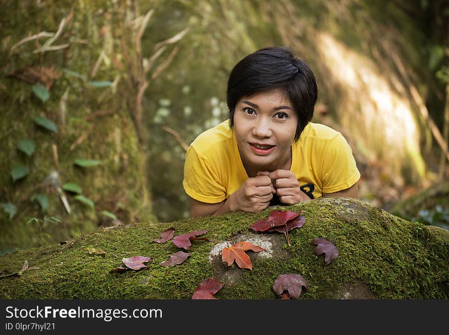 Portrait of a nice Asian girl holding with dry red-yellow maple