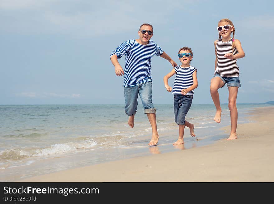 Father And Children Playing On The Beach At The Day Time.