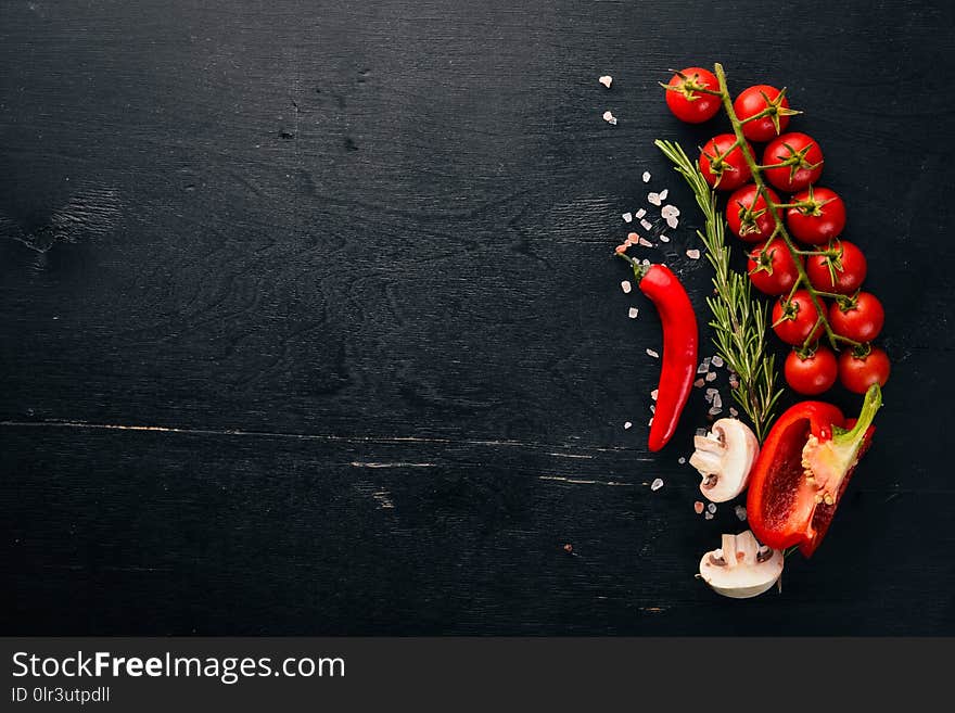 Preparation for cooking. Cherry tomatoes. Fresh vegetables and spices on a wooden background. Top view