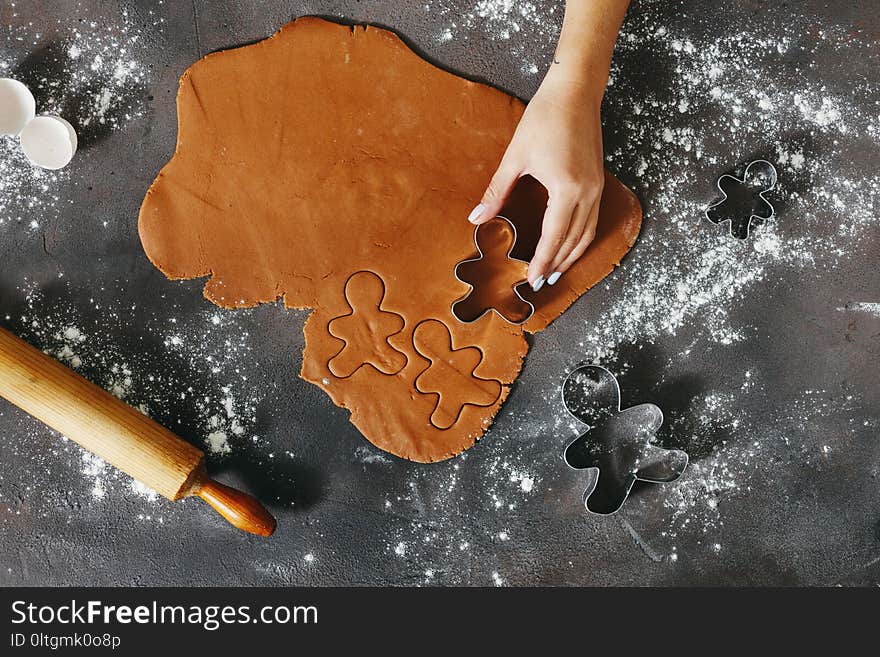 Woman hand preparing Christmas cookies ginger men top view. Woman hand preparing Christmas cookies ginger men top view