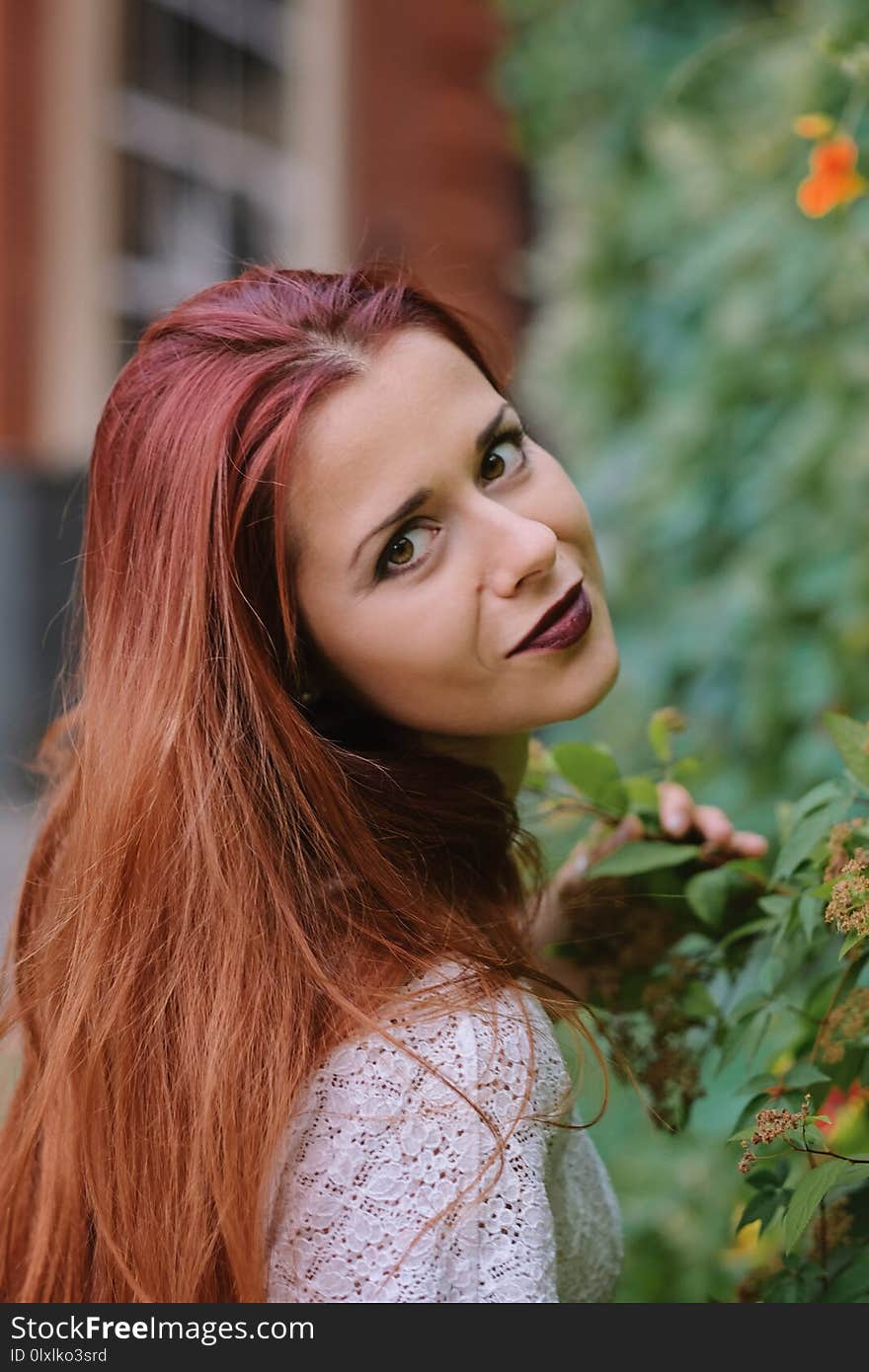 Fashion art photo. Portrait of woman with long red hair, in the city.