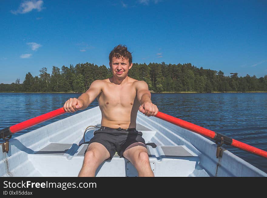 The man in a boat rowing on the lake