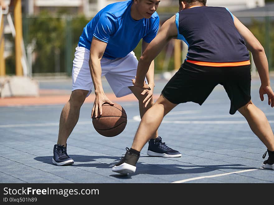 Young asian adult players playing basketball on outdoor court. Young asian adult players playing basketball on outdoor court.