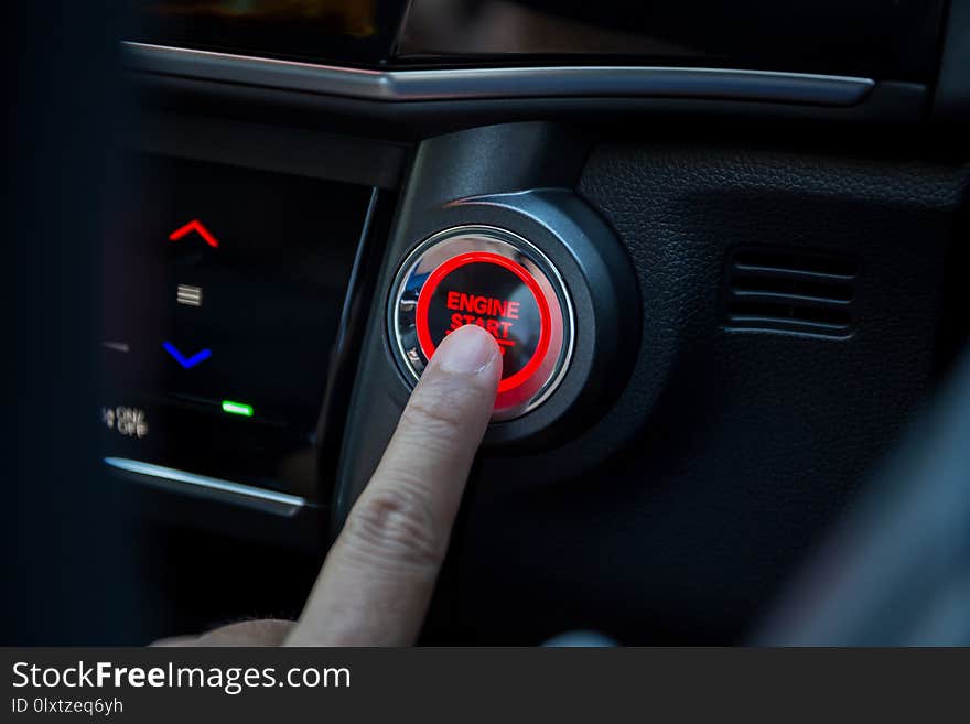 Fingers pressing car start button to start
