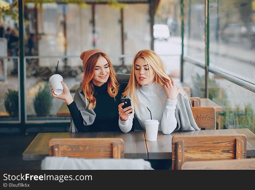 Girl sitting in the cafe at the table and drink coffee. Girl sitting in the cafe at the table and drink coffee