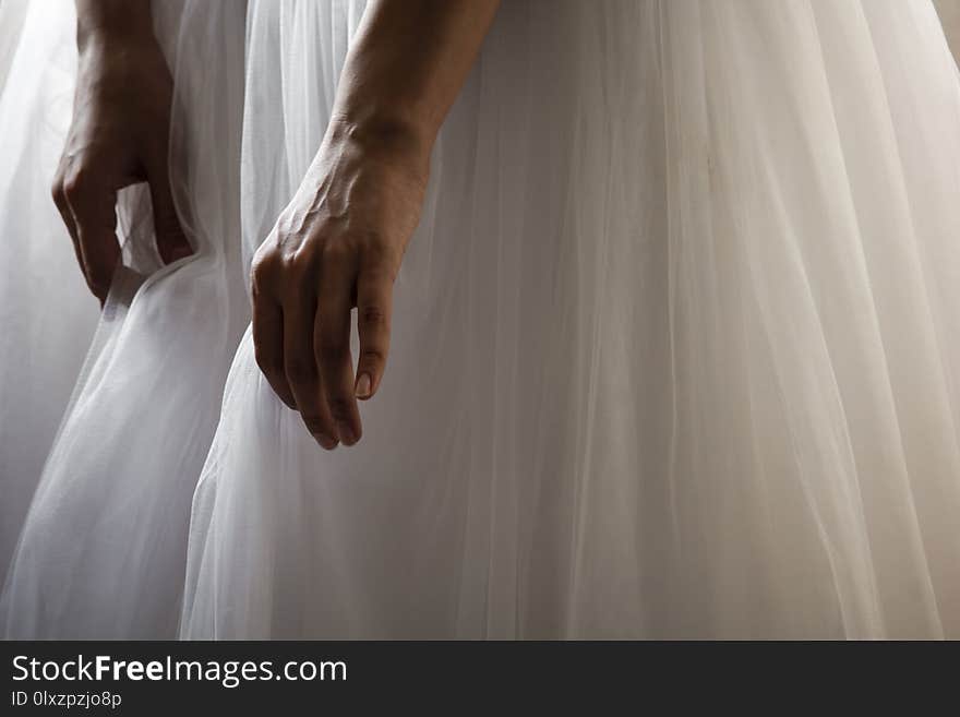 A bride in a beautiful wedding dress holding dress hem