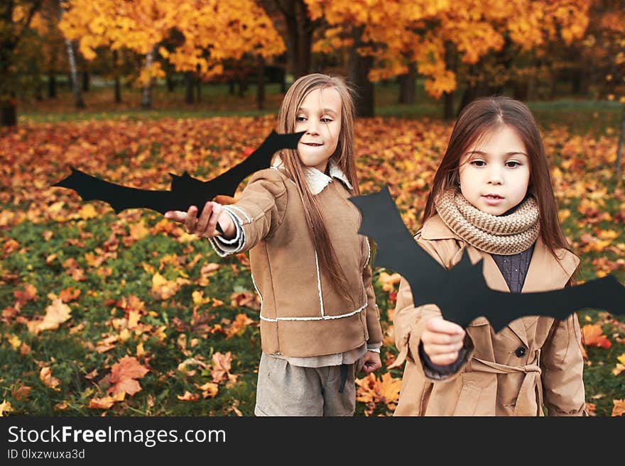 Halloween Bats. Two sisters playing in autumn park