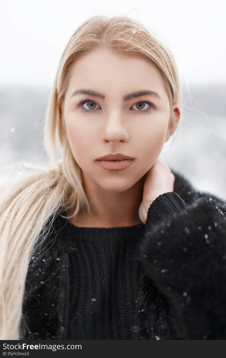 Portrait of a beautiful young blonde in a black jacket. Winter day. Portrait of a beautiful young blonde in a black jacket. Winter day