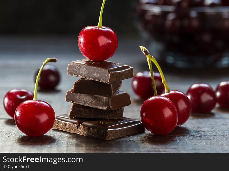 Cherries and broken chocolate on a dark background. Cherries and broken chocolate on a dark background.