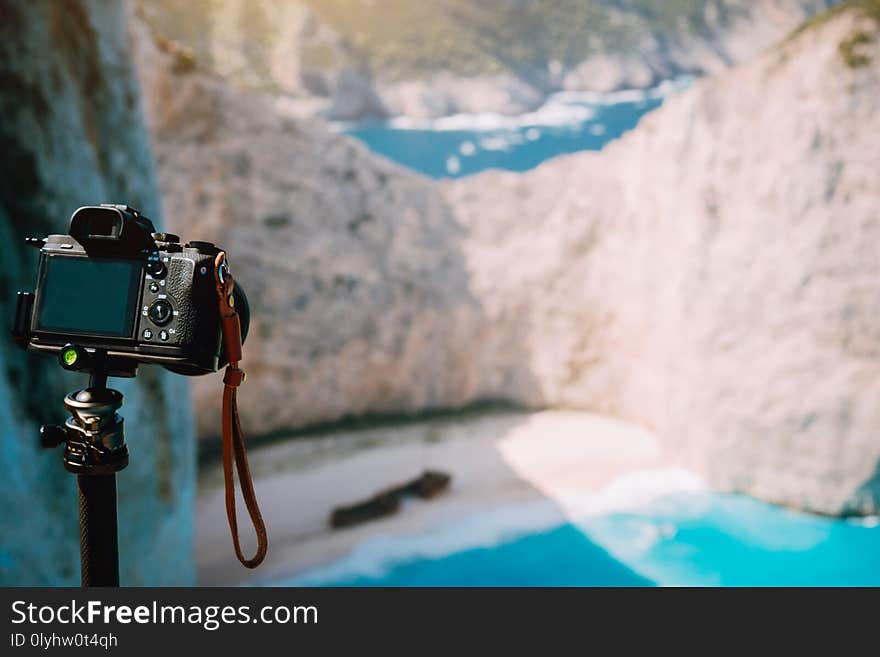 Digital camera on tripod capture photo of Shipwreck in Navagio beach in morning sun light. Famous visiting landmark