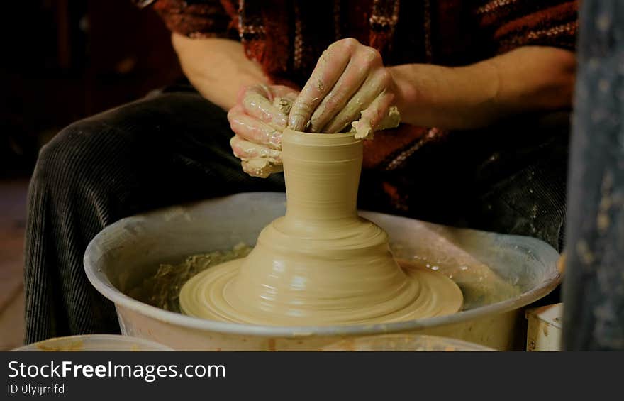 Professional male potter making mug in pottery workshop