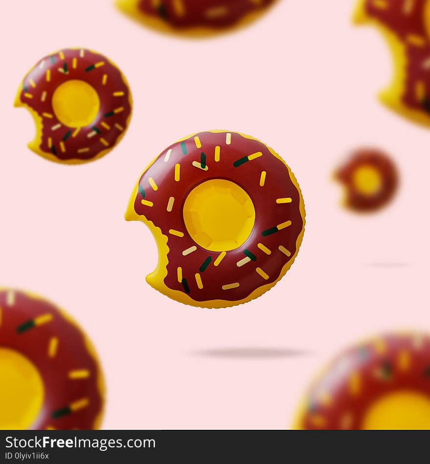 Inflatable donut pool toy on pink background.