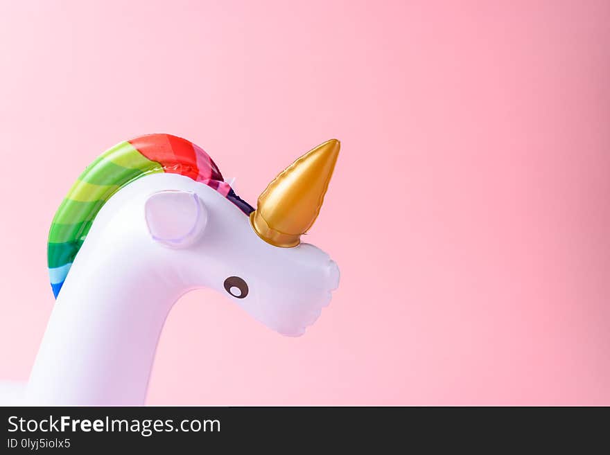 Inflatable Unicorn Pool Toy On Pink Background.