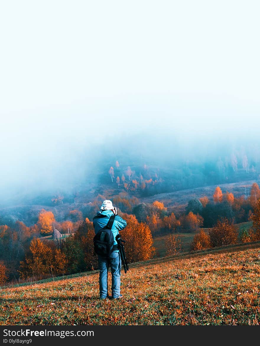 Photographer taking photo of autumn landscape