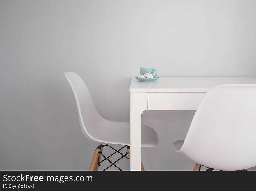 Turquoise Cup Of Tea And Meringue On A White Table Near White Chairs