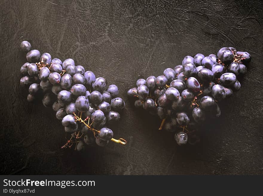 Fresh ripe Bunches of black Grapes berries on kitchen table Concept of cooking jam compote winemaking autumn homemade harvest of agriculture top view with copy space.