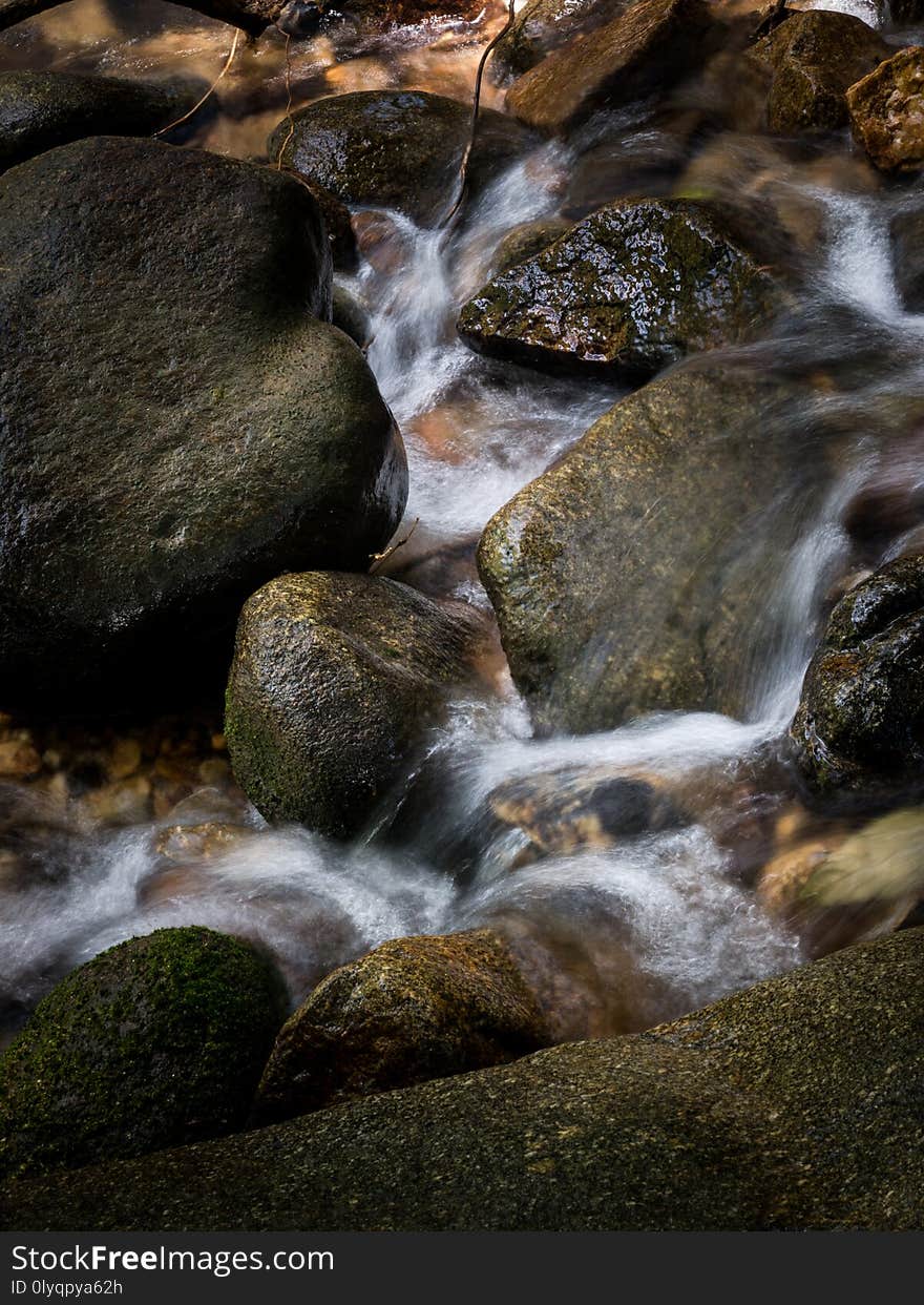 mountain stream creek waterfall flowing through rocks in a tropical forest.