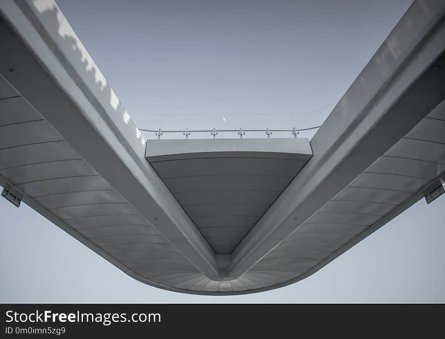 White bridge with transparent fence on sky background and small hardly noticeable moon