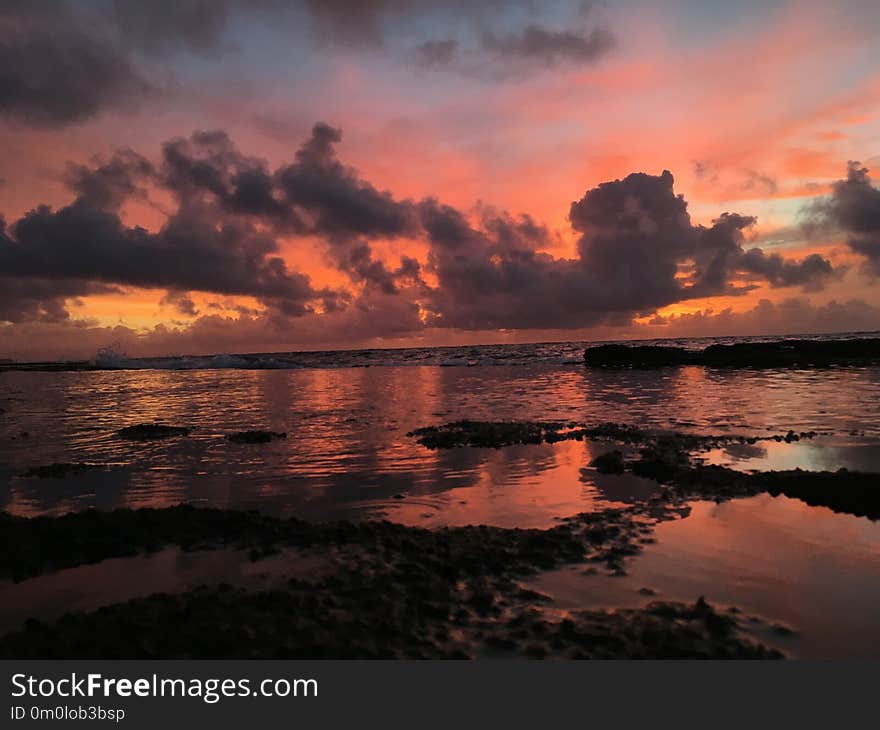 Dawn above Pacific Ocean Seen from Reef on Beach in Kapaa on Kauai Island in Hawaii.