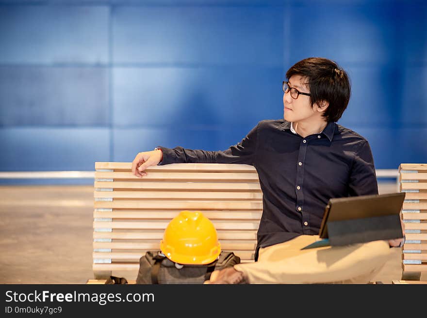 Asian engineer man using digital tablet on bench