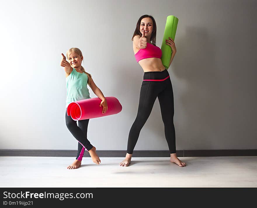 Young women having fun with kid after yoga. Family sport concept. Young women having fun with kid after yoga. Family sport concept