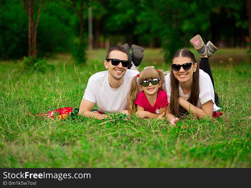 Happy young family spending time outdoor on summer day. Happiness and harmony in family life