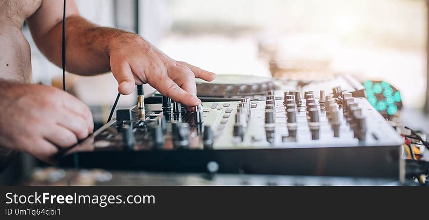 Close up of Disc Jockey hands plays music with DJ CD player and mixer on a private summer day party. Close up of Disc Jockey hands plays music with DJ CD player and mixer on a private summer day party