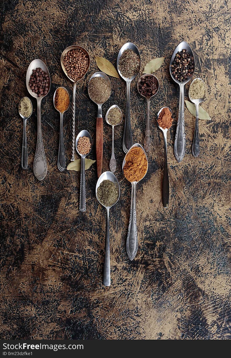 Different spices in spoons on a vintage background. Copy space for your text.Top view.