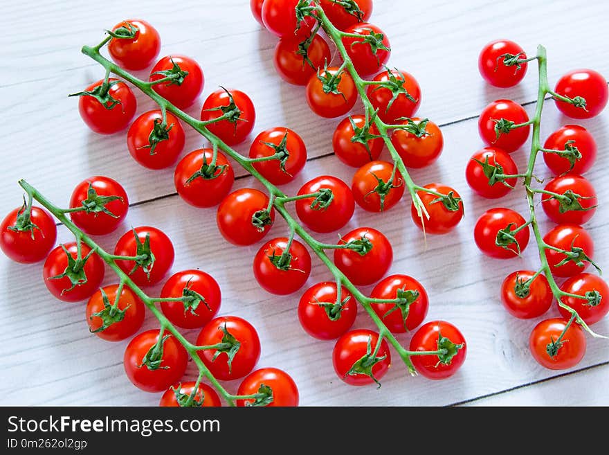 Bright red cherry tomatoes at white wooden table