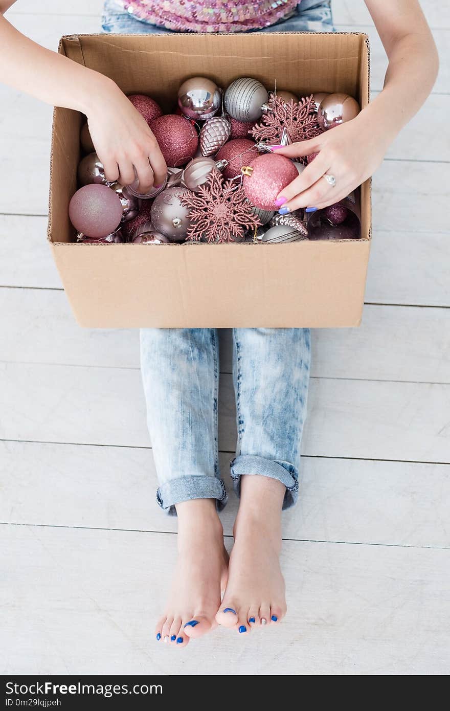 Happy christmas traditions of home and fir tree decoration, woman choosing the best adornments from a box with new year balls and toys mix. Happy christmas traditions of home and fir tree decoration, woman choosing the best adornments from a box with new year balls and toys mix.