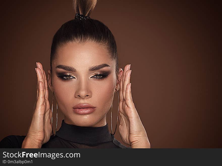 Face of attractive woman in golden makeup.