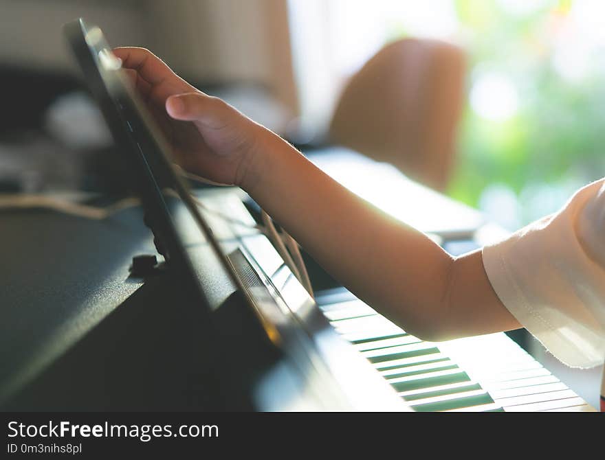 Little Boy playing with piano and Music Tablet at home