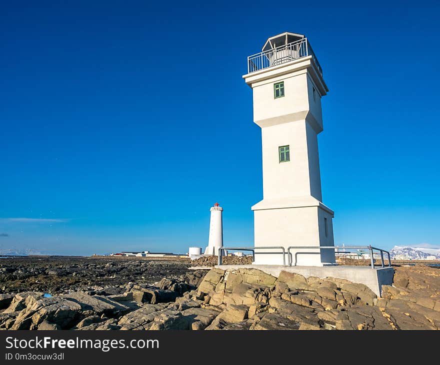 The old inactive Arkranes lighthouse at end of peninsula, was built since 1918, under blue sky, Iceland. The old inactive Arkranes lighthouse at end of peninsula, was built since 1918, under blue sky, Iceland