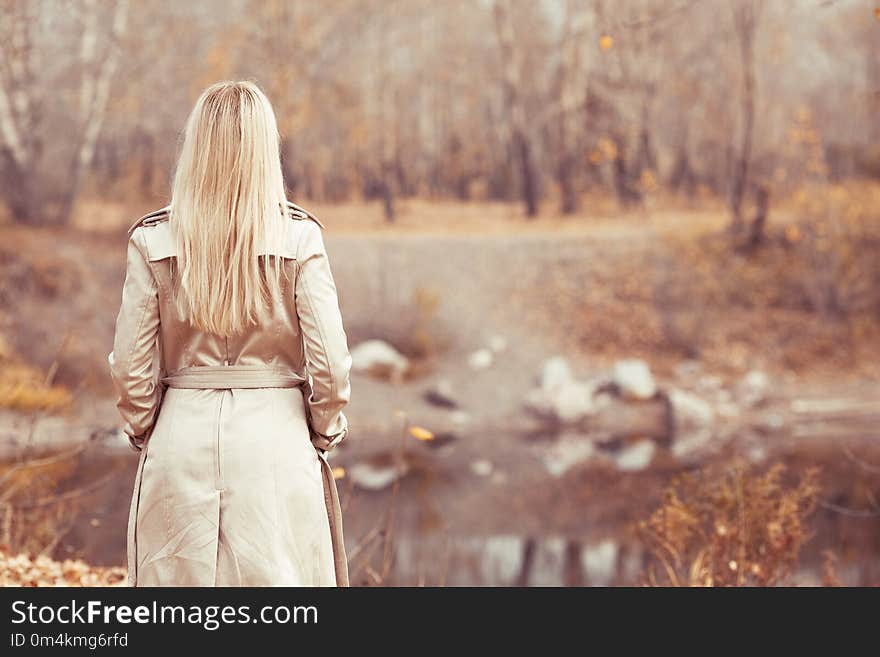 Stylish blond woman walking in the autumn park. Stylish blond woman walking in the autumn park